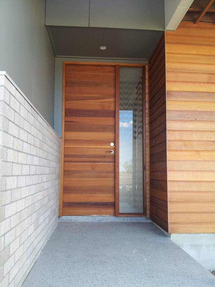 Источник вдохновения для домашнего уюта: большая входная дверь в современном стиле с серыми стенами, бетонным полом, одностворчатой входной дверью и входной дверью из дерева среднего тона
