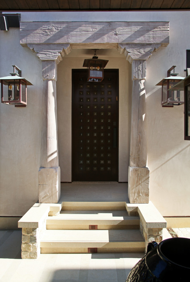 На фото: входная дверь среднего размера в восточном стиле с бежевыми стенами, полом из травертина, одностворчатой входной дверью и черной входной дверью с