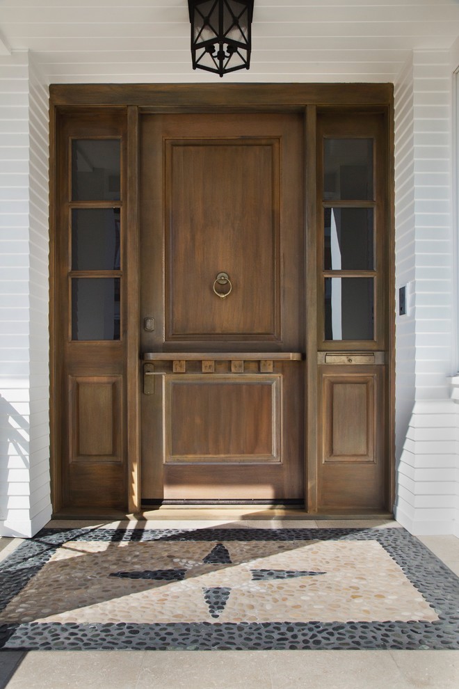 Réalisation d'une grande porte d'entrée chalet avec une porte hollandaise, un mur blanc, une porte en bois brun et un sol multicolore.