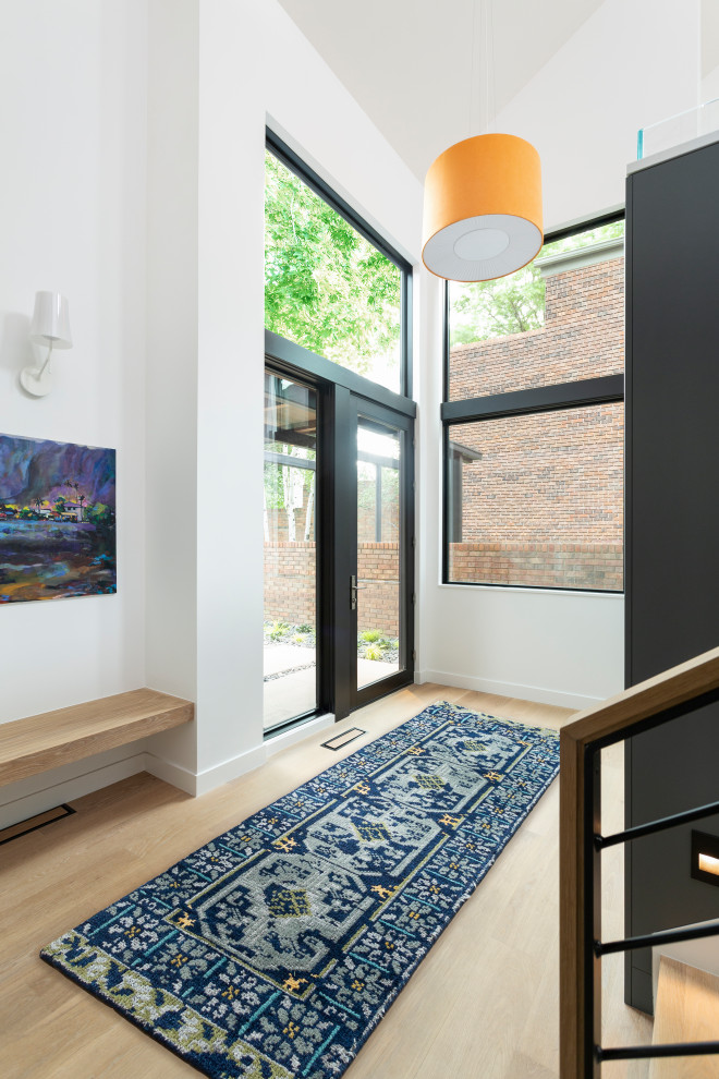 Mittelgroße Moderne Haustür mit weißer Wandfarbe, hellem Holzboden, Einzeltür, schwarzer Haustür, beigem Boden, gewölbter Decke und Holzwänden in Denver