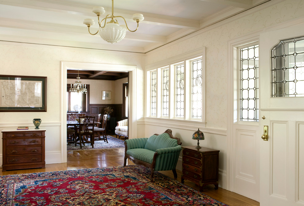 На фото: большое фойе в викторианском стиле с белыми стенами, паркетным полом среднего тона, одностворчатой входной дверью и белой входной дверью