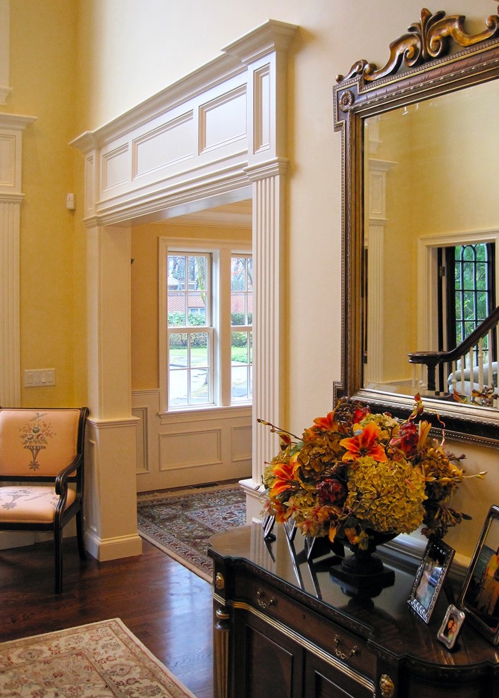Esempio di un grande ingresso chic con pareti bianche, pavimento in legno massello medio e pavimento marrone