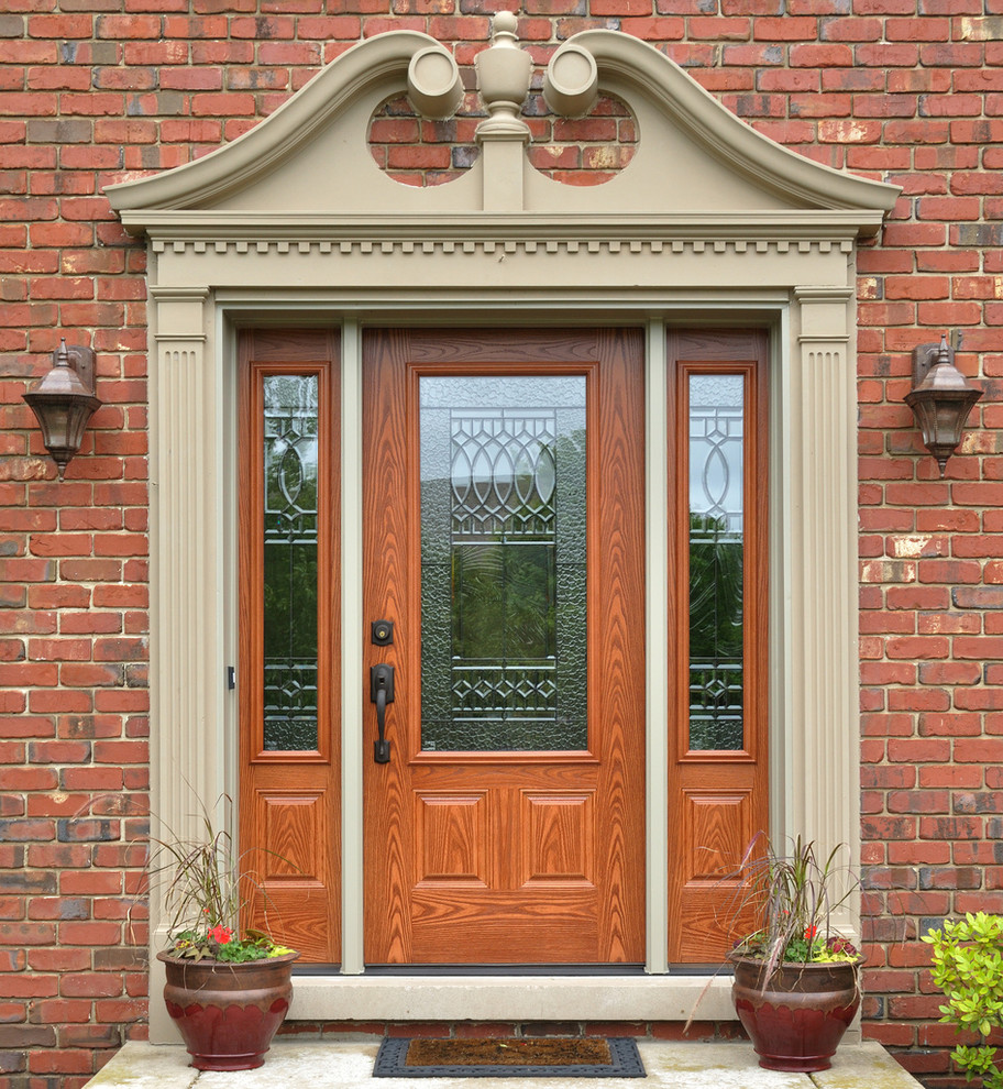 Foto di una porta d'ingresso tradizionale di medie dimensioni con pavimento in cemento, una porta singola, una porta in legno bruno e pavimento grigio