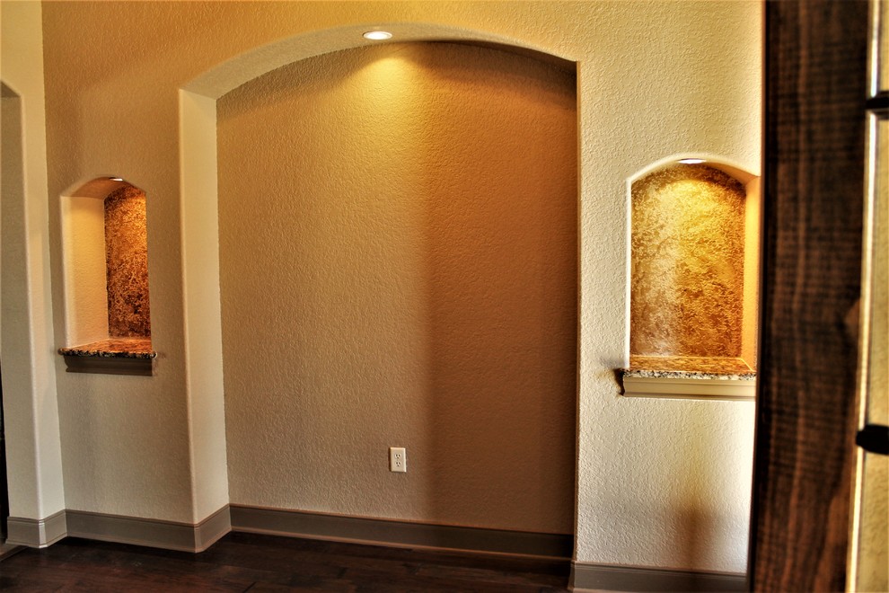 Cette photo montre un grand hall d'entrée chic avec un mur beige, parquet foncé et un sol marron.