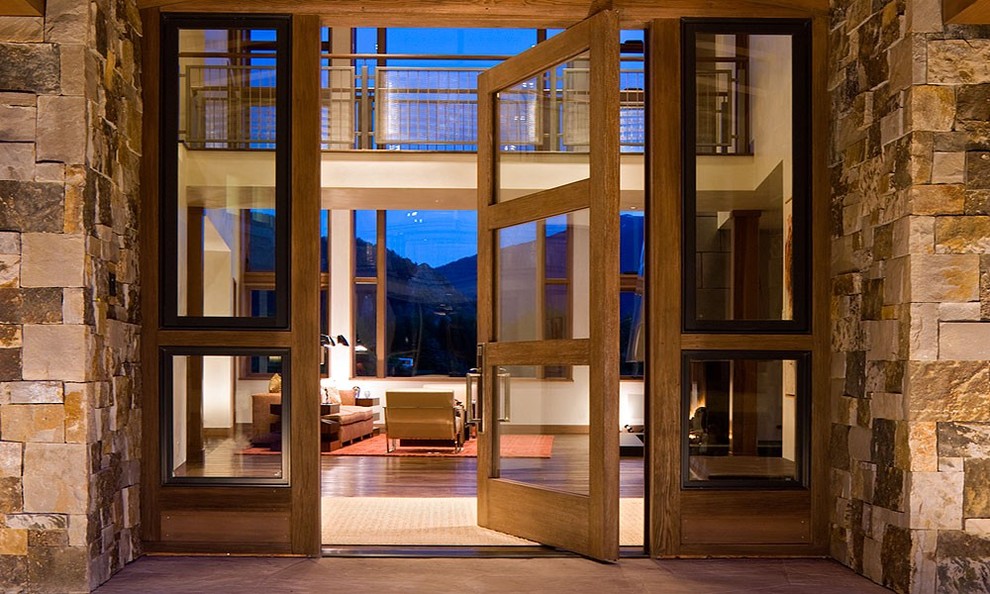 Photo of a contemporary entrance in Denver with a pivot front door, a glass front door and dark hardwood flooring.