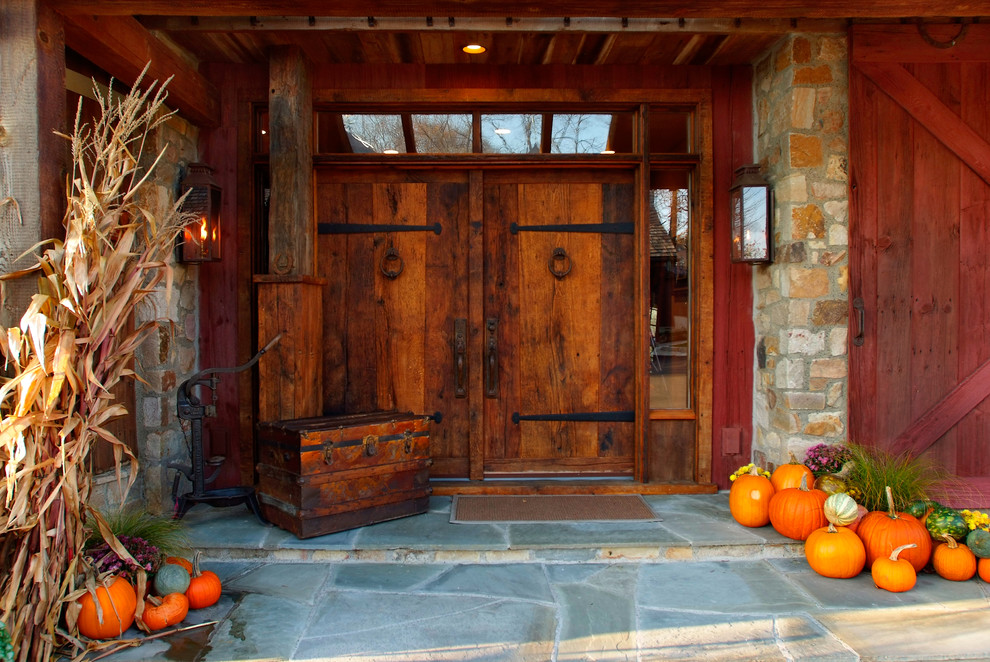 Aménagement d'une grande porte d'entrée campagne avec une porte double et une porte en bois foncé.