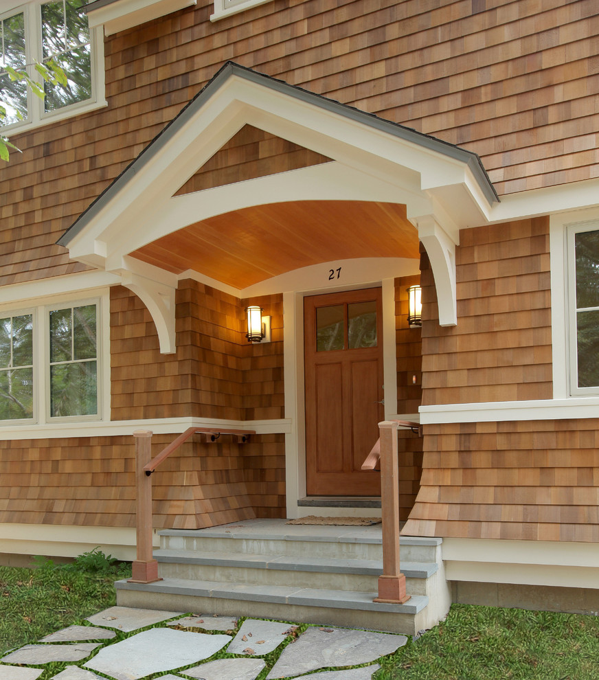 Réalisation d'une grande porte d'entrée tradition avec une porte simple, une porte en bois brun, un mur marron et un sol en carrelage de céramique.