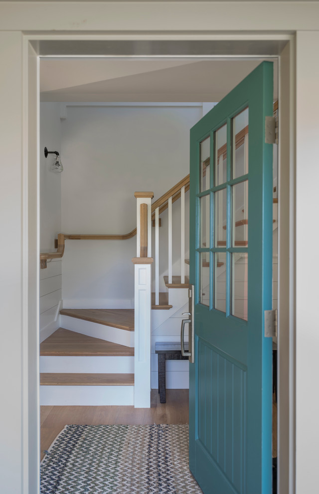 Cette photo montre une porte d'entrée bord de mer de taille moyenne avec un mur beige, parquet clair, une porte simple, une porte bleue et un sol marron.