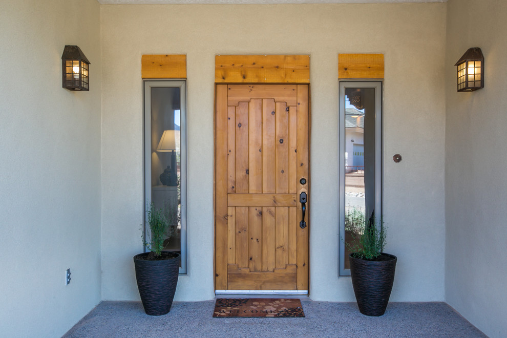 Geräumige Mediterrane Haustür mit weißer Wandfarbe, Betonboden, Einzeltür und heller Holzhaustür in Albuquerque