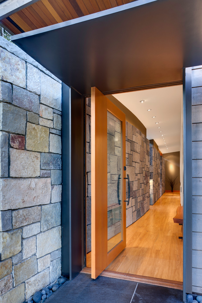 Mittelgroße Moderne Haustür mit Drehtür, braunem Holzboden, hellbrauner Holzhaustür und grauer Wandfarbe in Seattle