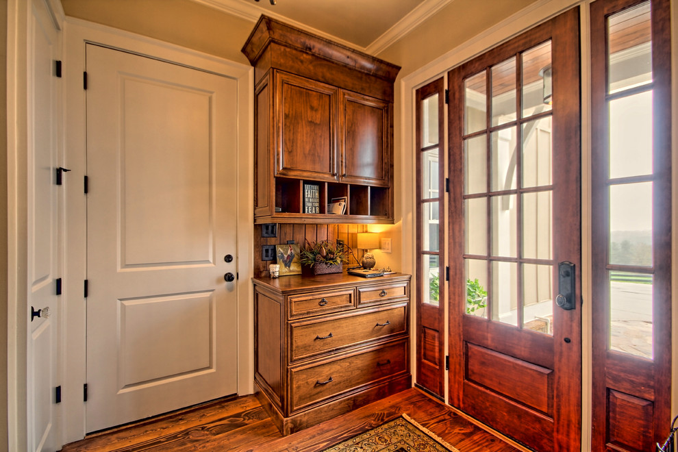 Inspiration pour une porte d'entrée chalet de taille moyenne avec un mur beige, un sol en bois brun, une porte simple et une porte en bois foncé.