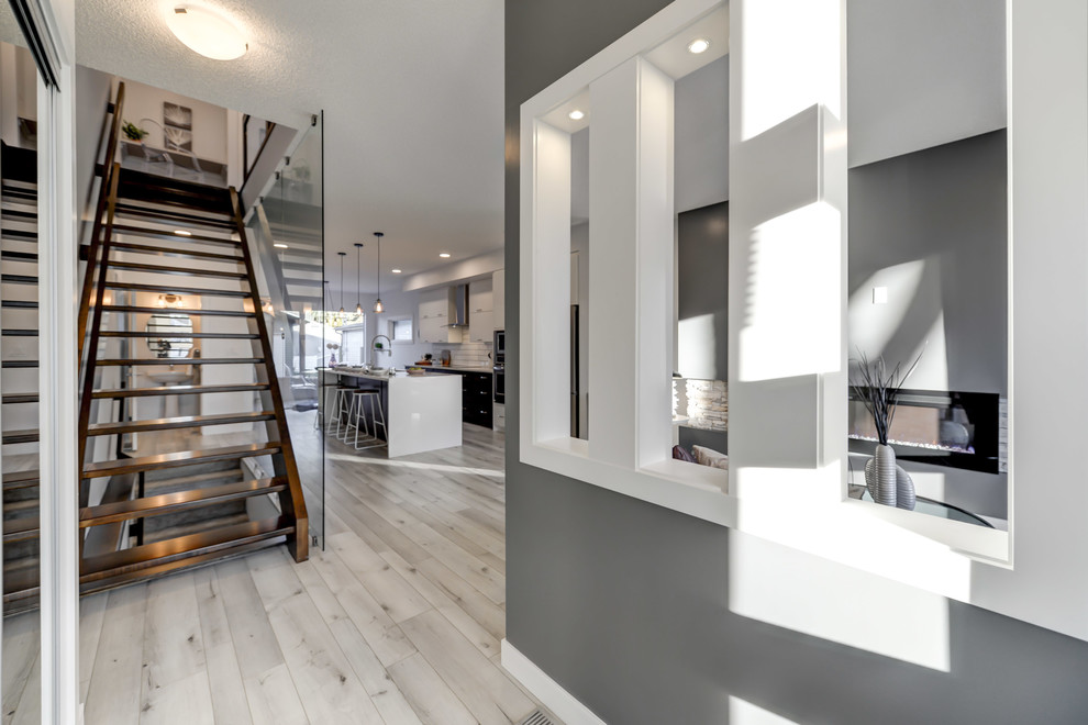 Idée de décoration pour un petit hall d'entrée design avec un mur gris, un sol en vinyl, une porte simple et un sol blanc.