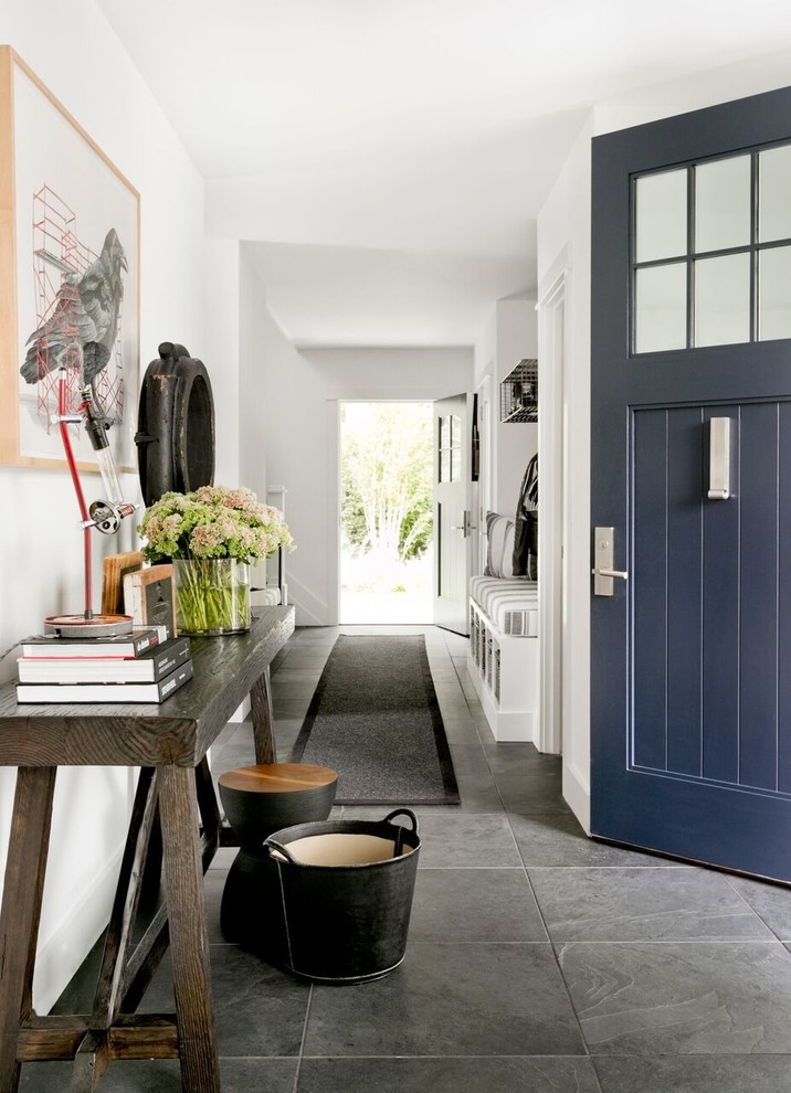 Immagine di un ampio ingresso country con pareti bianche, pavimento in ardesia, una porta singola, una porta blu e pavimento nero
