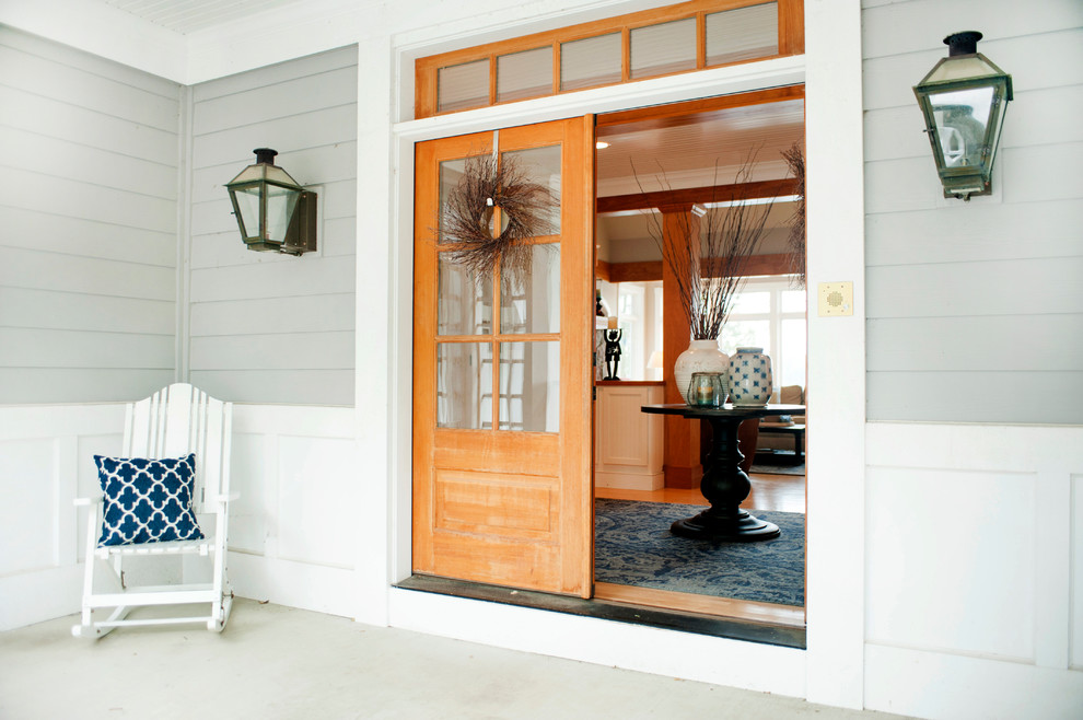 Ispirazione per una porta d'ingresso american style di medie dimensioni con pareti grigie, pavimento in cemento, una porta a due ante e una porta in legno chiaro