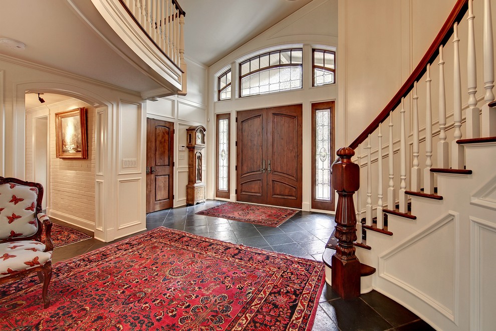 Idées déco pour un grand hall d'entrée classique avec un mur blanc, une porte simple et une porte en bois brun.