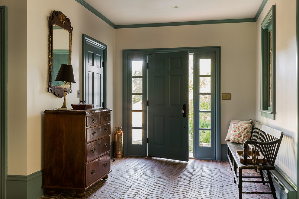 Elegant brick floor entryway photo in Boston with a blue front door and beige walls