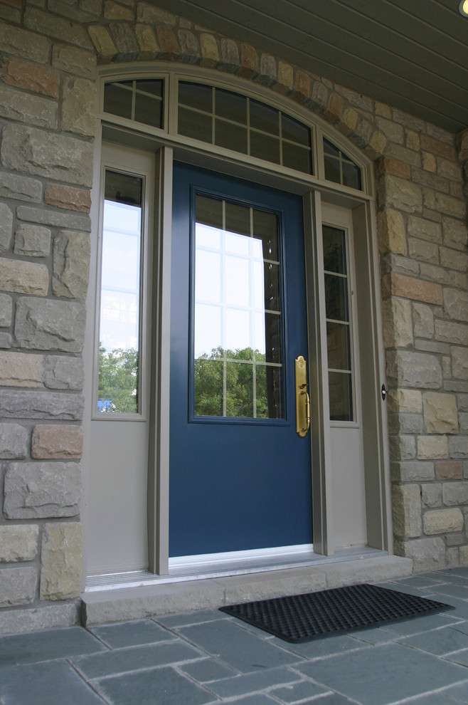 グランドラピッズにある高級な巨大なミッドセンチュリースタイルのおしゃれな玄関ドア (ベージュの壁、スレートの床、青いドア) の写真