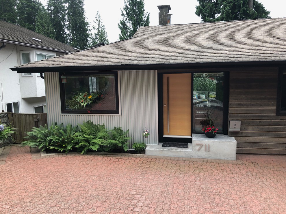 Mid-Century Eingang mit Einzeltür und heller Holzhaustür in Vancouver
