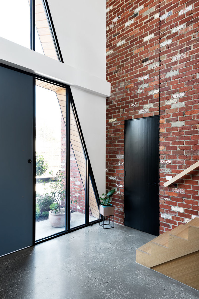 Mittelgroßes Modernes Foyer mit Betonboden, Drehtür, schwarzer Haustür, grauem Boden und weißer Wandfarbe in Melbourne