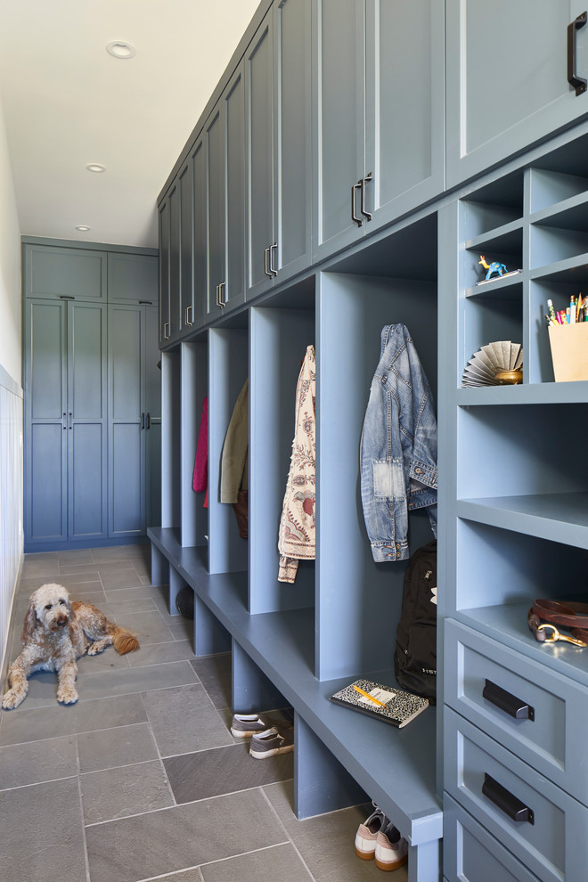Photo of an expansive nautical boot room in Austin with grey floors.