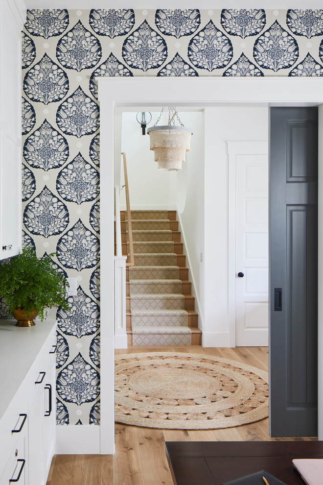 Ispirazione per un ampio ingresso stile marino con pareti bianche, pavimento in legno massello medio, una porta singola, una porta marrone e pavimento beige
