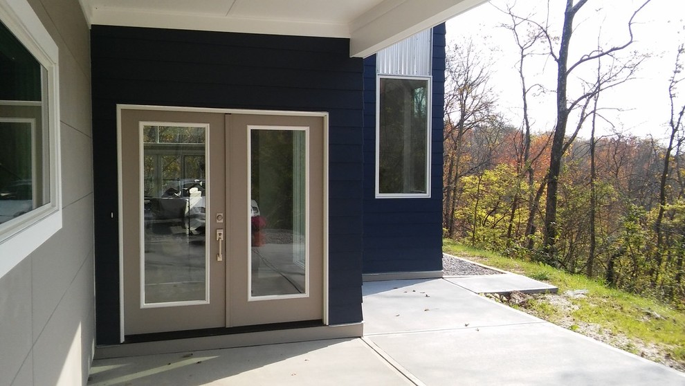 Idées déco pour une porte d'entrée moderne de taille moyenne avec un mur bleu, sol en béton ciré, une porte double et une porte en verre.