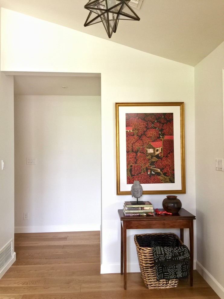 This is an example of a medium sized contemporary foyer in Phoenix with white walls, light hardwood flooring, a single front door and a white front door.