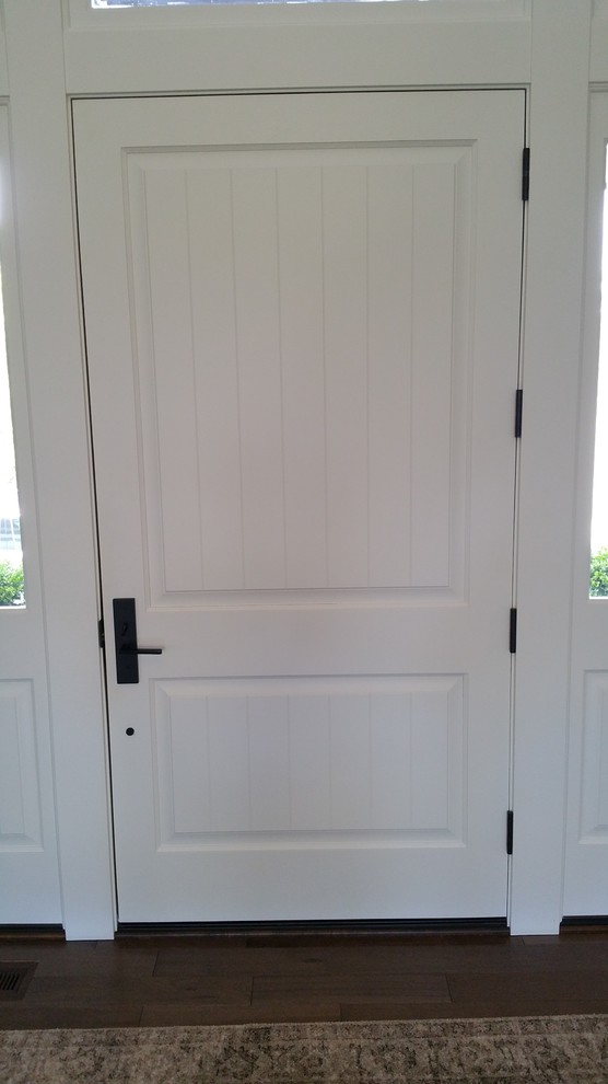 Cette photo montre une entrée tendance avec un mur gris, une porte simple et une porte blanche.