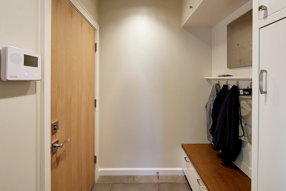 Photo of a medium sized contemporary boot room in Seattle with beige walls, slate flooring, a single front door and a medium wood front door.