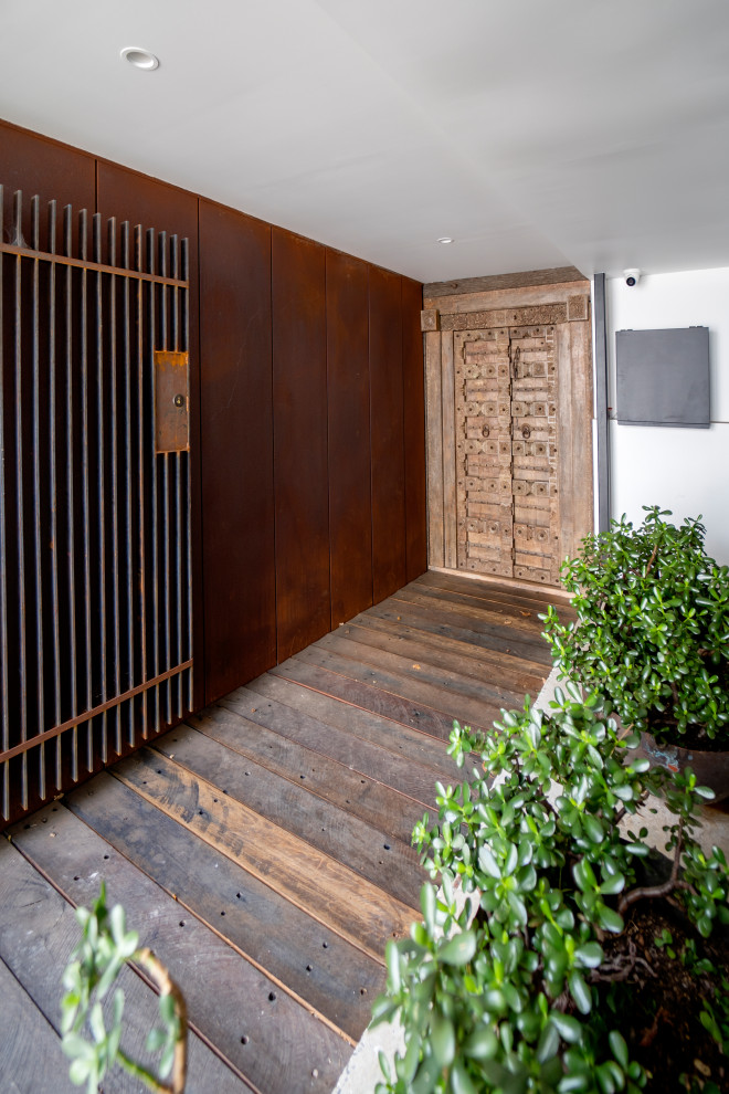 Diseño de puerta principal asiática extra grande con paredes metalizadas, suelo de madera clara, puerta doble, puerta de madera en tonos medios y suelo marrón