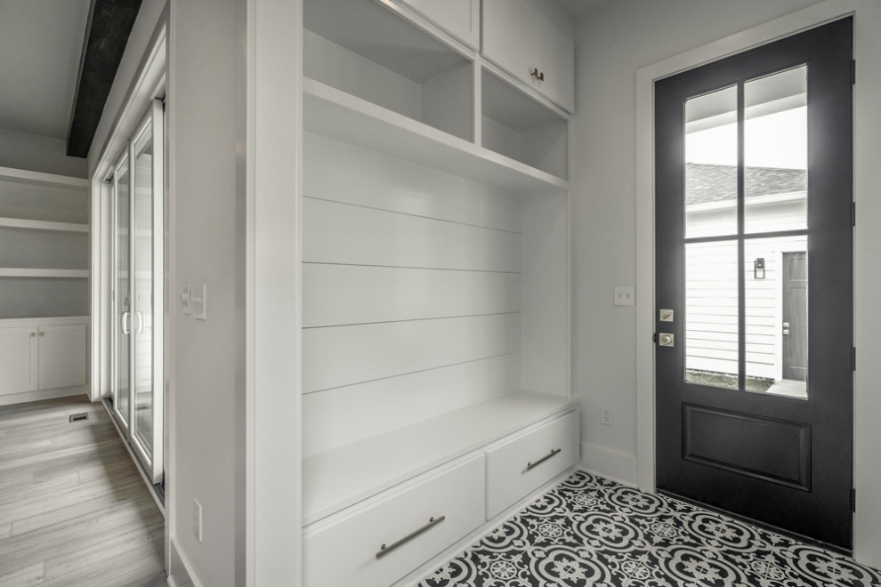 Modelo de vestíbulo posterior minimalista con paredes blancas, suelo de baldosas de cerámica, puerta simple, puerta negra y suelo negro
