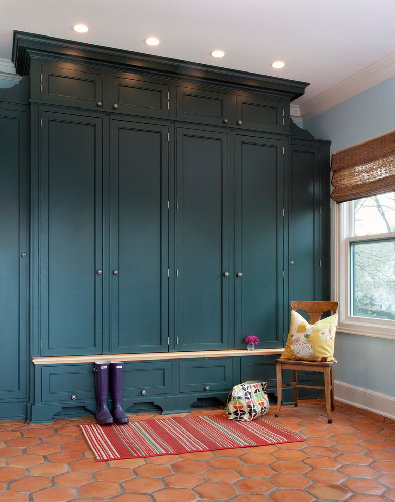 Elegant terra-cotta tile and red floor mudroom photo in Chicago
