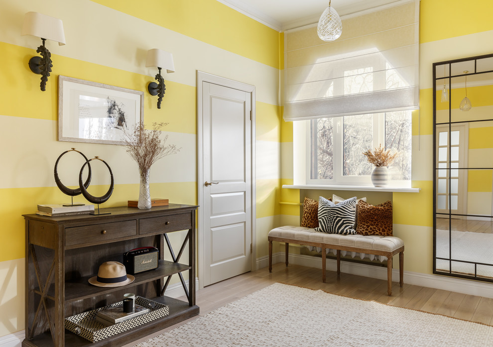 Idee per un ingresso con vestibolo eclettico con pareti gialle, parquet chiaro e pavimento beige