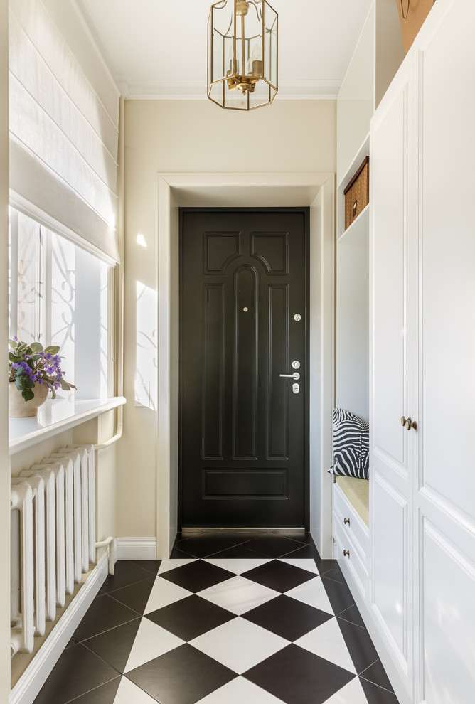 Exemple d'une porte d'entrée chic avec un mur beige, une porte simple, une porte noire et un sol multicolore.