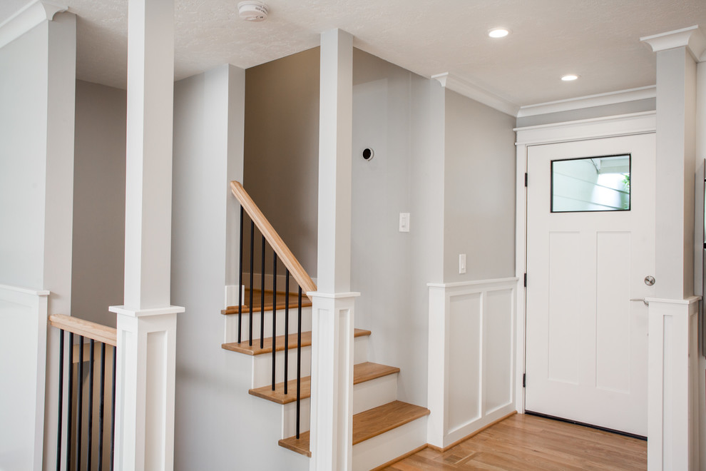 This is an example of a small classic front door in Other with grey walls, light hardwood flooring, a single front door, a white front door and beige floors.