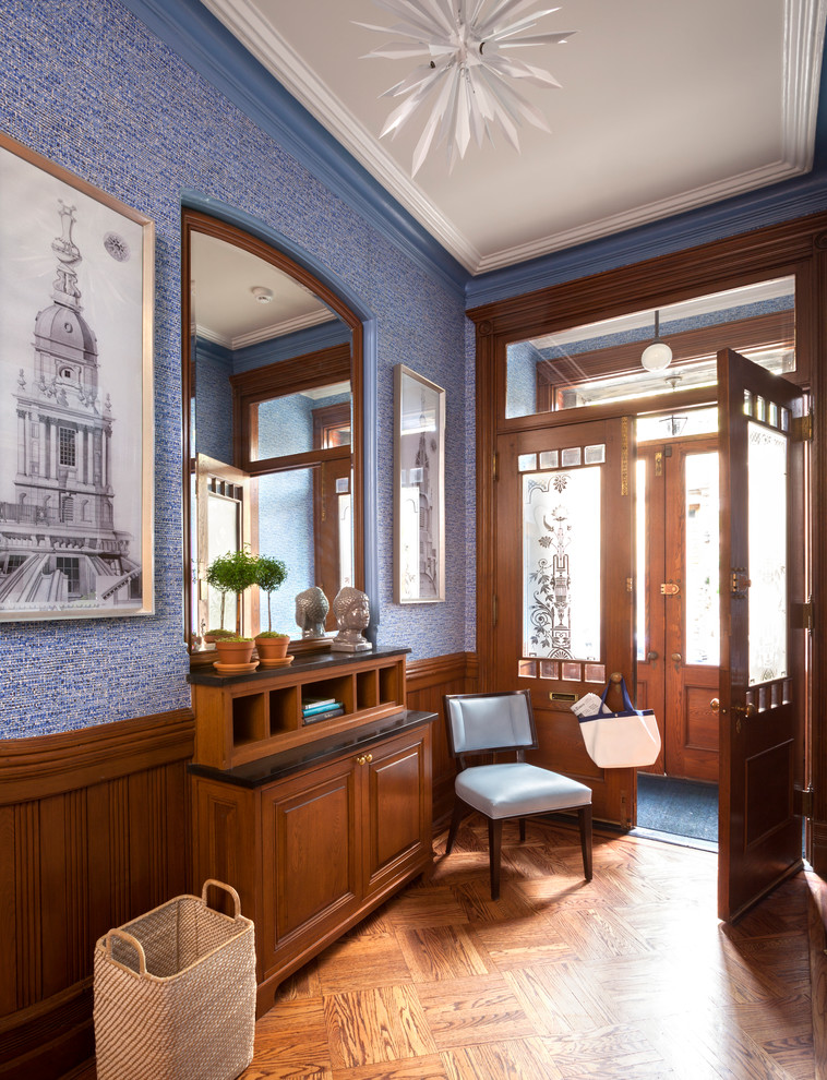 Пример оригинального дизайна: узкая прихожая в викторианском стиле с синими стенами, паркетным полом среднего тона, двустворчатой входной дверью, стеклянной входной дверью и коричневым полом