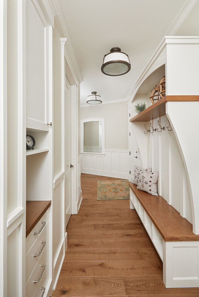 Esempio di un ingresso o corridoio chic con pareti bianche, pavimento in legno massello medio e pavimento marrone
