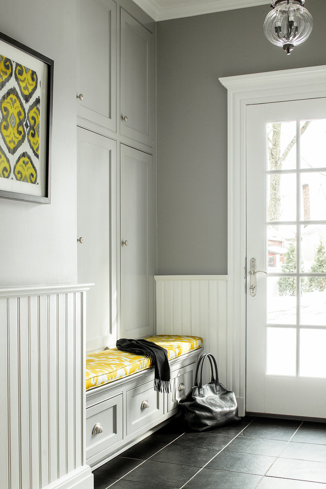 Стильный дизайн: прихожая в классическом стиле с серыми стенами, одностворчатой входной дверью, стеклянной входной дверью и черным полом - последний тренд