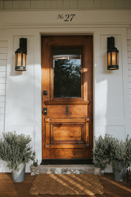 Esempio di una porta d'ingresso american style di medie dimensioni con pavimento in legno massello medio, una porta singola, una porta in legno bruno e pavimento marrone