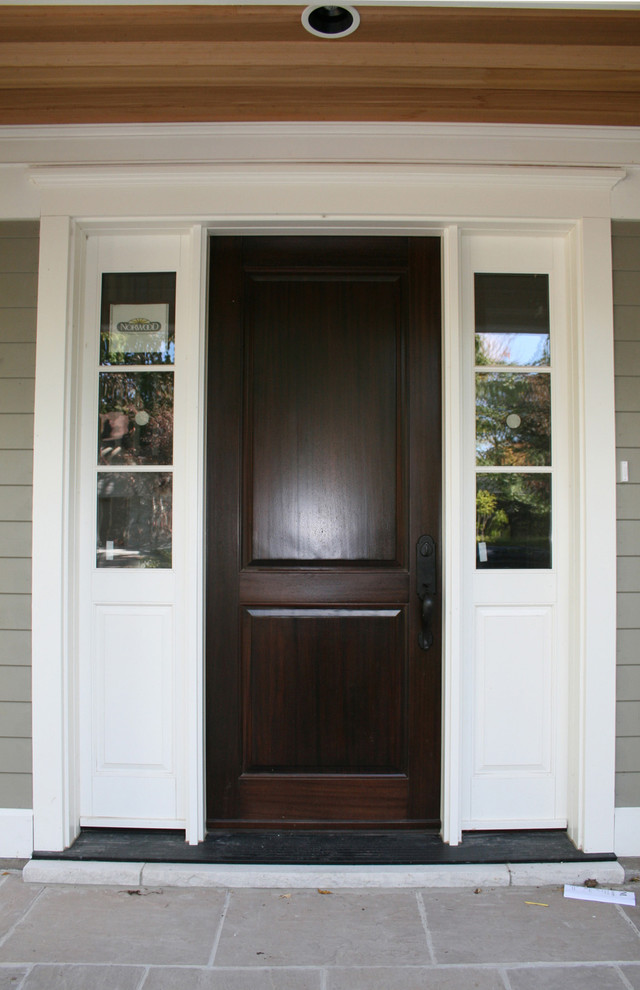 На фото: входная дверь среднего размера в классическом стиле с серыми стенами, одностворчатой входной дверью и входной дверью из темного дерева с