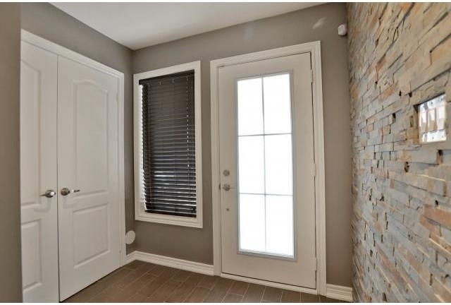 Foto på en funkis foajé, med grå väggar, klinkergolv i keramik, en enkeldörr och en vit dörr