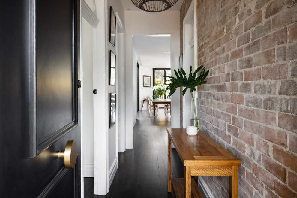 Moderner Eingang mit Korridor, weißer Wandfarbe, gebeiztem Holzboden, Einzeltür, schwarzer Haustür, schwarzem Boden und Ziegelwänden in Sydney