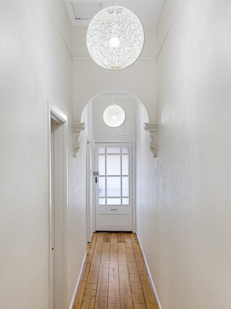 Großer Klassischer Eingang mit Korridor, weißer Wandfarbe, hellem Holzboden, Einzeltür und schwarzer Haustür in Melbourne
