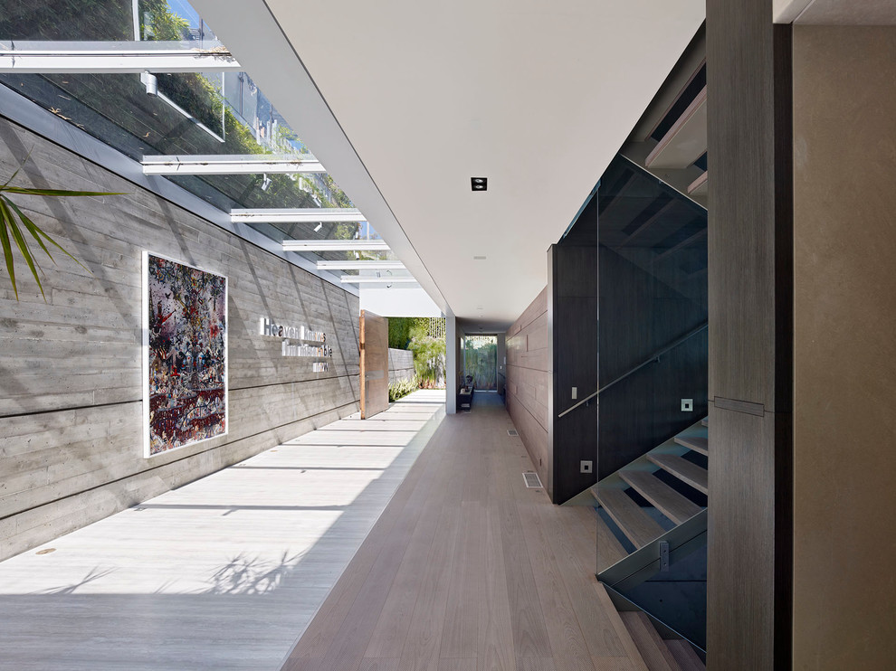 Geräumiger Moderner Eingang mit Korridor, grauer Wandfarbe, Porzellan-Bodenfliesen, Drehtür, hellbrauner Holzhaustür und beigem Boden in Los Angeles