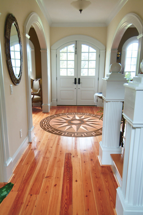 Example of a classic light wood floor entryway design in Other with beige walls and a white front door