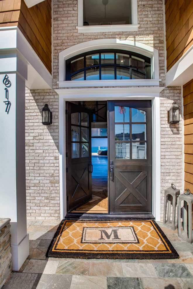 Imagen de puerta principal costera con puerta doble, puerta de madera oscura, suelo de pizarra y suelo multicolor