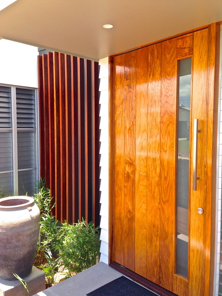 Ejemplo de puerta principal minimalista de tamaño medio con paredes blancas, suelo de baldosas de cerámica, puerta pivotante y puerta de madera en tonos medios