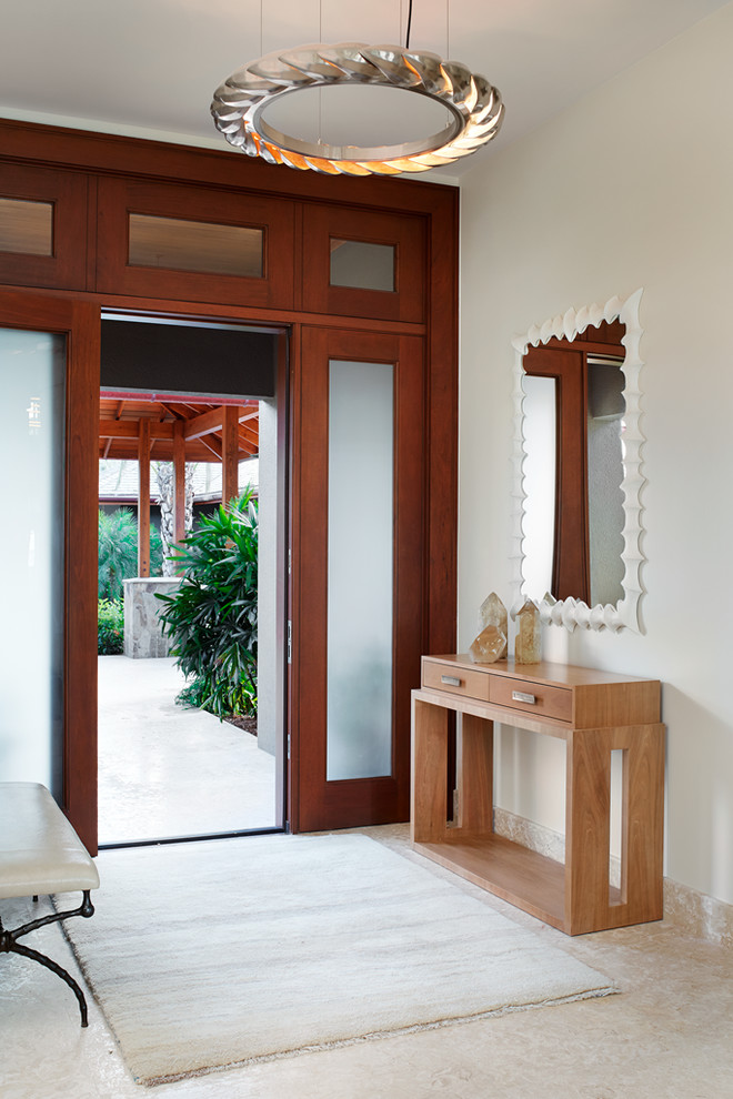 他の地域にあるトロピカルスタイルのおしゃれな玄関ロビー (白い壁、木目調のドア) の写真