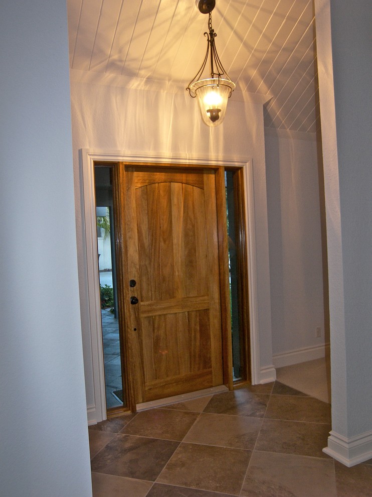 Источник вдохновения для домашнего уюта: входная дверь среднего размера в стиле неоклассика (современная классика) с синими стенами, полом из керамогранита, одностворчатой входной дверью и входной дверью из светлого дерева