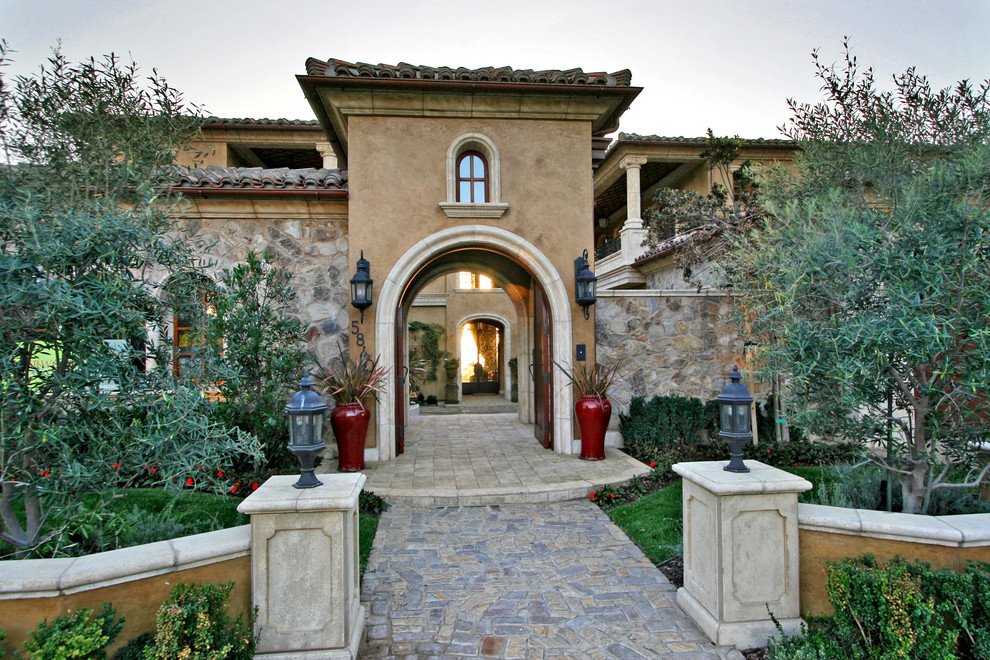 Geräumige Mediterrane Haustür mit Doppeltür, brauner Wandfarbe, Backsteinboden, hellbrauner Holzhaustür und grauem Boden in San Diego